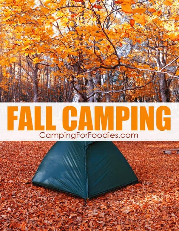 Fall camping is EXHILARATING! This is a photo of a tent set up during the fall camping season. A green tent is set up on the ground which is covered by red, orange and yellow autumn leaves. The surrounding forest has trees that are displaying brilliant colored leaves that are in the process of changing colors as they fall from the trees. Text over image reads fall camping introducing a CampingForFoodies post with tips for camping during the autumn season.