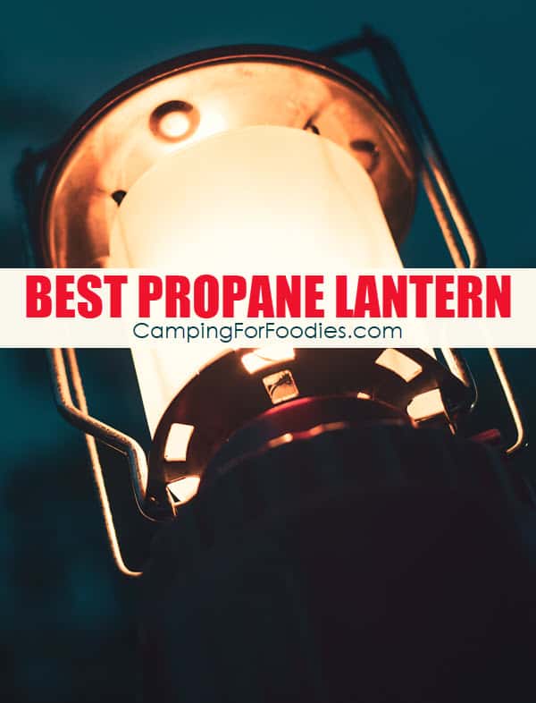 Dura Best Propane Lanterns Reviewed by CampingForFoodies features a propane camping lantern softly lit against a deep blue night sky at a campsite with text over image reading best propane lantern.