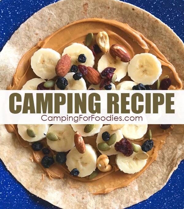 Fruit And Nut Peanut Butter Stuffed Tortilla Camping Recipe by CampingForFoodies features a whole wheat tortilla laying on a blue camping plate with peanut butter, banana slices, dried fruit, nuts and seeds layered on top and ready to be rolled up to be eaten with text over the image reading camping recipe.