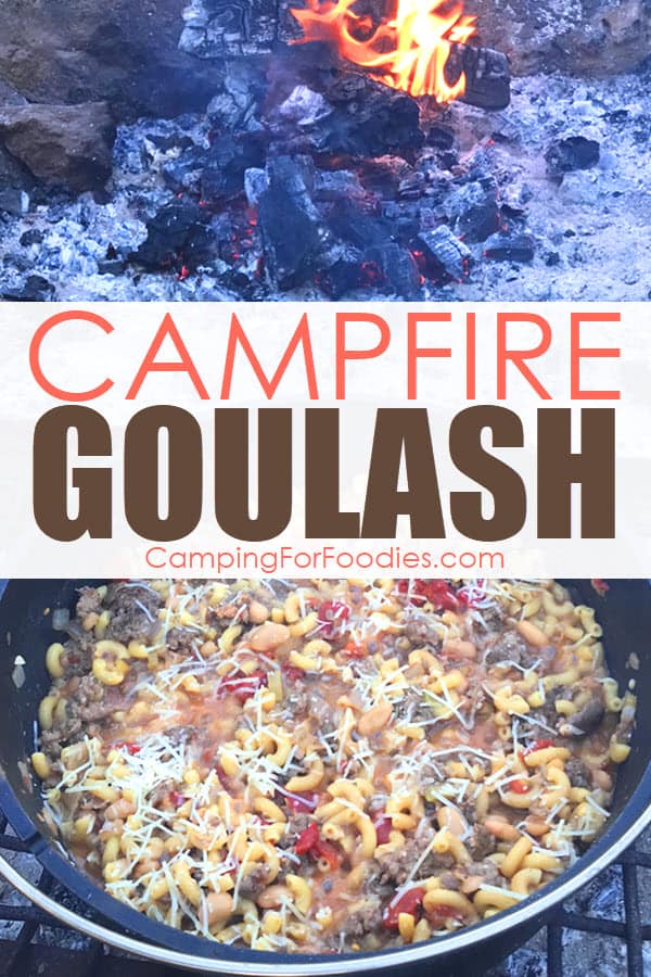 Campfire Goulash by CampingForFoodies features a cast iron camp Dutch oven sitting on a grate in a campfire ring with a campfire burning in the background, the pot is filled with goulash and sprinkled with parmesan cheese and ready to be served with text over the image that reads campfire goulash.