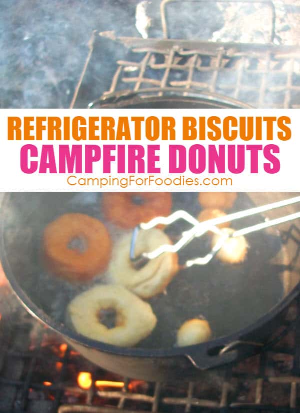 Refrigerator Biscuits Dutch Oven Campfire Donuts by CampingForFoodies features donuts and donut holes frying in a cast iron Dutch oven sitting on a grate in a campfire ring, they are golden brown on one side and some are just being flipped to cook the other side with text over the image that reads refrigerator biscuits campfire donuts.