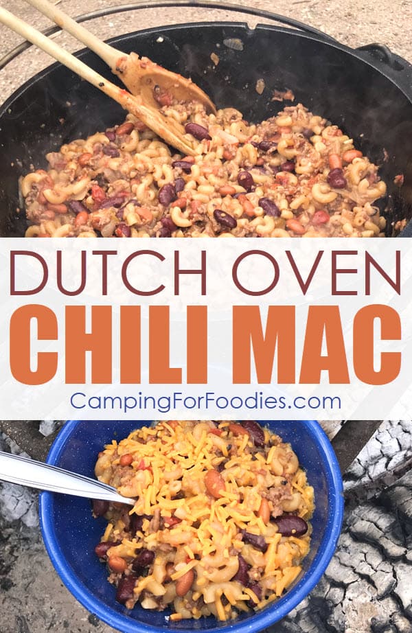 Dutch Oven Chili Mac by CampingForFoodies features a cast iron camp Dutch oven sitting over a campfire on a cooking grate, it is filled with chili mac that is being served, another single portion is placed alongside the Dutch oven in a blue camping bowl with a spoon in it and ready to eat with text over the image that reads Dutch Oven Chili Mac.