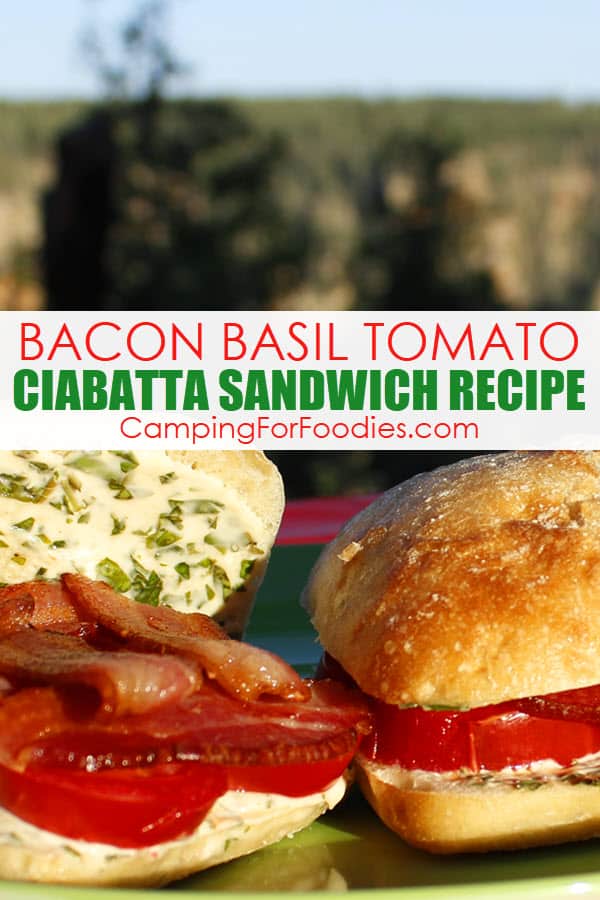 Bacon Basil Tomato BBT Ciabatta Sandwich Recipe by CampingForFoodies features two ciabatta sandwiches on a green plate. One sandwich is closed next to another one that has the upper bun setting up against the lower bun that is piled with golden brown bacon and deep red tomato slices. Green and white basil mayonnaise is spread on the inside of the top and bottom buns. There is text over the image that reads bacon basil tomato ciabatta sandwich recipe.