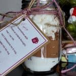 DIY Campfire Hot Cocoa Mix in a Mason Jar by CampingForFoodies features a mason jar filled with layers of sugar, cocoa powder and marshmallows. A cute instruction is hanging on the jar with twine that is wrapped around the neck of the jar.